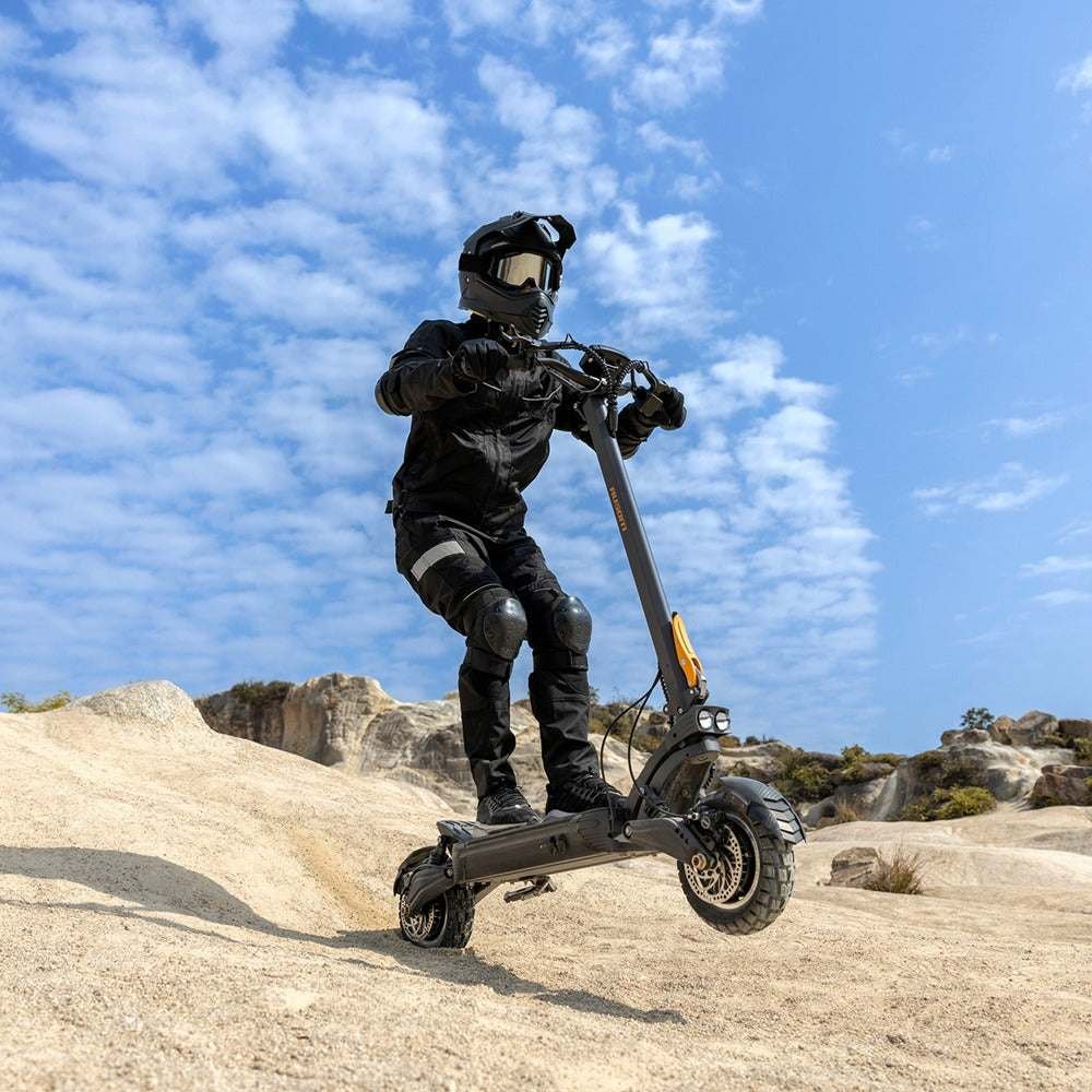 Rider climbing a desert trail on the Ausom F1 Max electric scooter