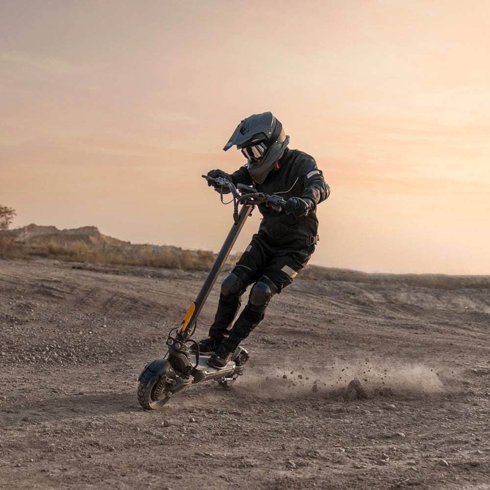 Rider kicking up dust on the Ausom F1 Max at sunset — off-road action shot