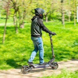 Rider on the Ausom DT2 Pro electric scooter on a park trail wearing a helmet