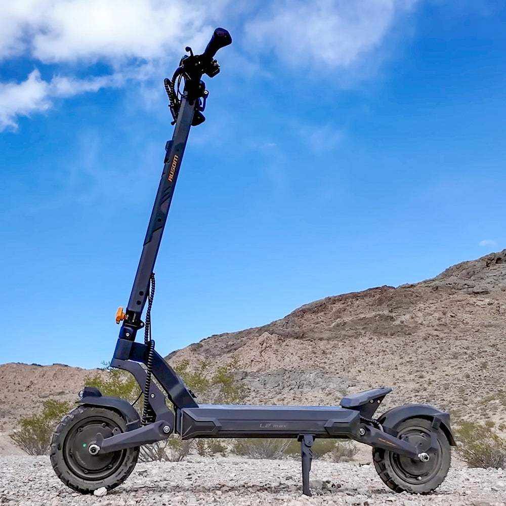 Ausom L2 Max Dual Motor electric scooter outdoors against desert hills — low-angle side view