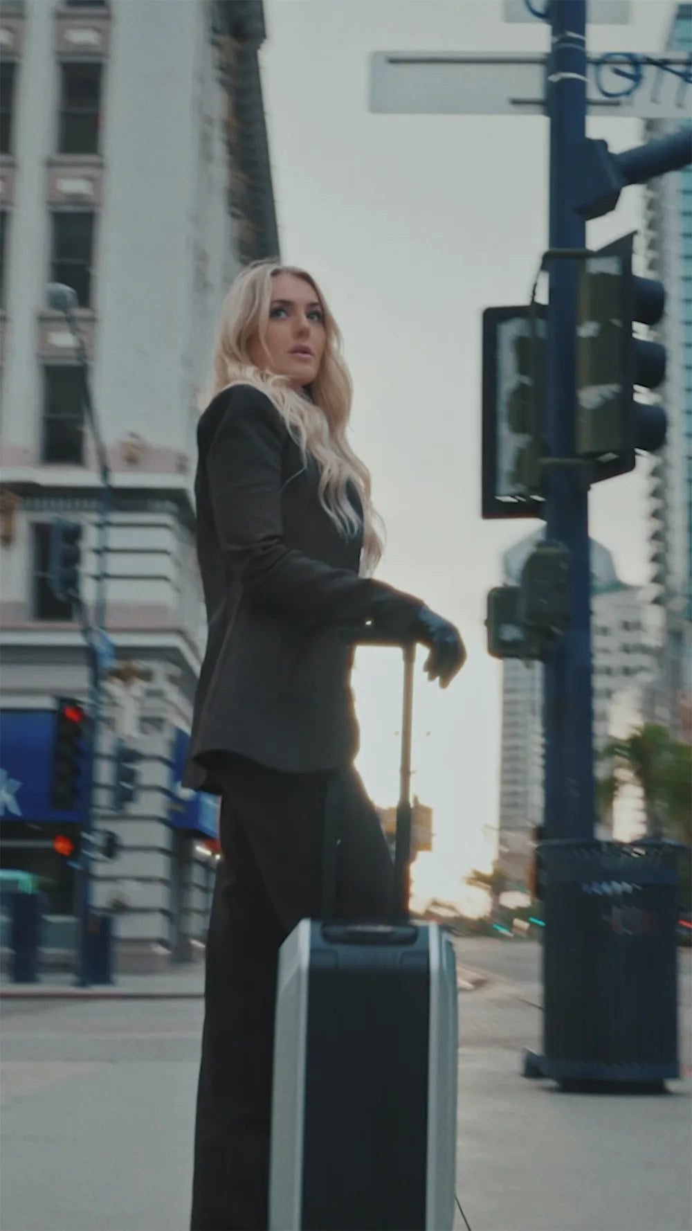 Traveler standing with an AOTOS L2 rideable suitcase in the city