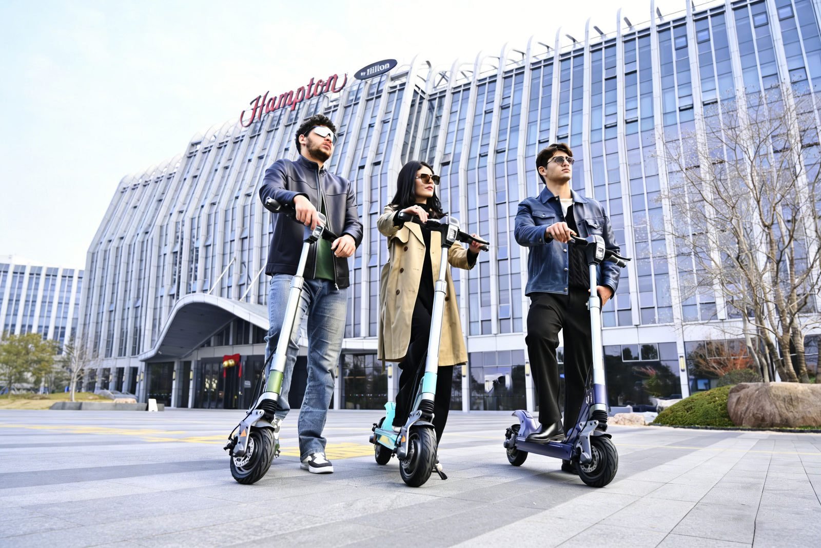 Three riders with E-TWOW TankTorq TK3 electric scooters in a city plaza