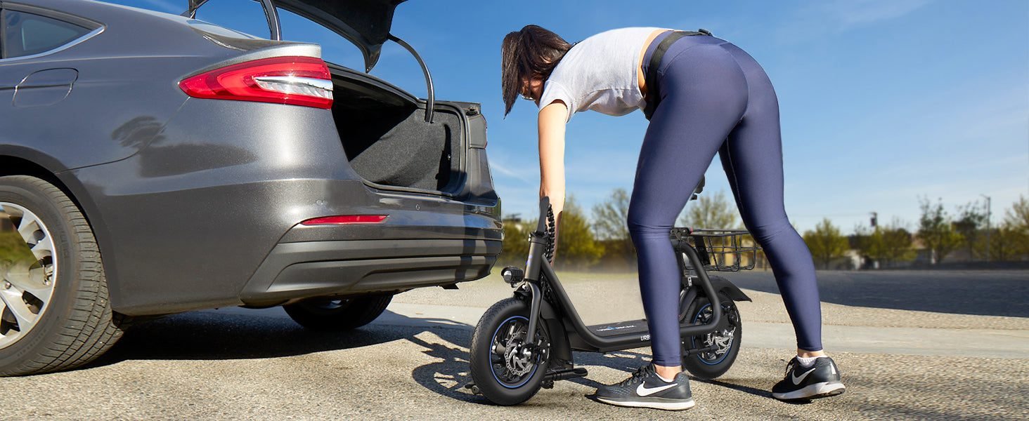 Rider folding the C1 seated scooter by a car trunk