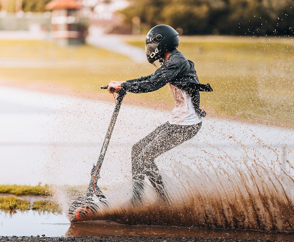 Climber scooter splashing through a puddle