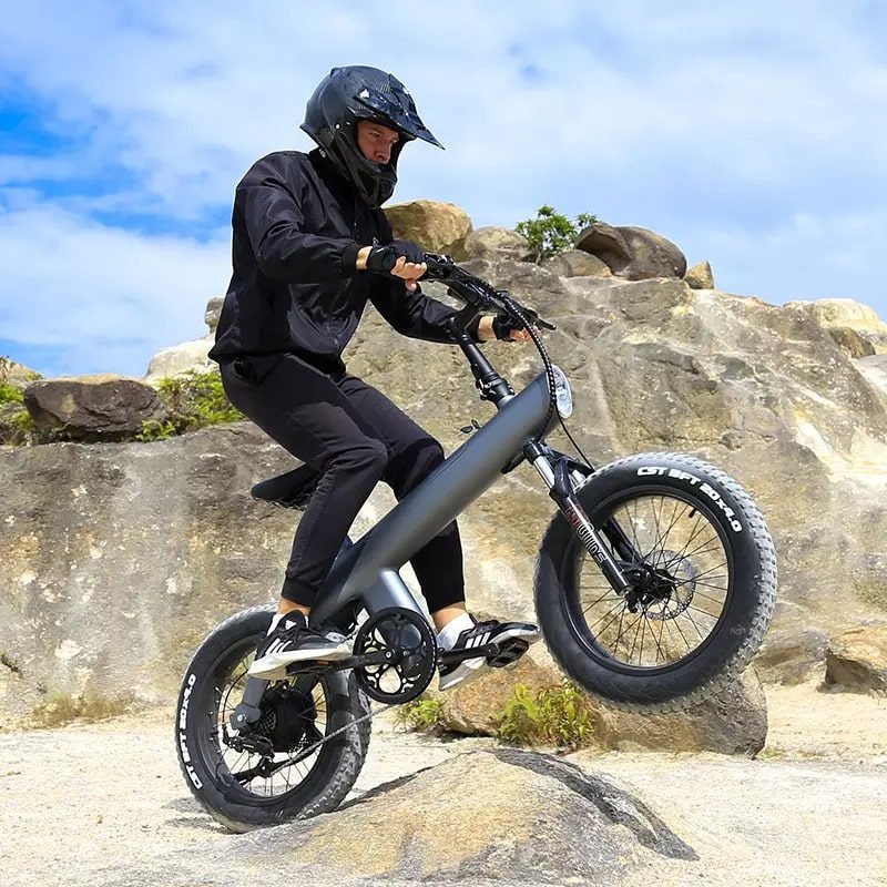 Rider seated on the Q3 fat tire electric bike on a rocky ledge
